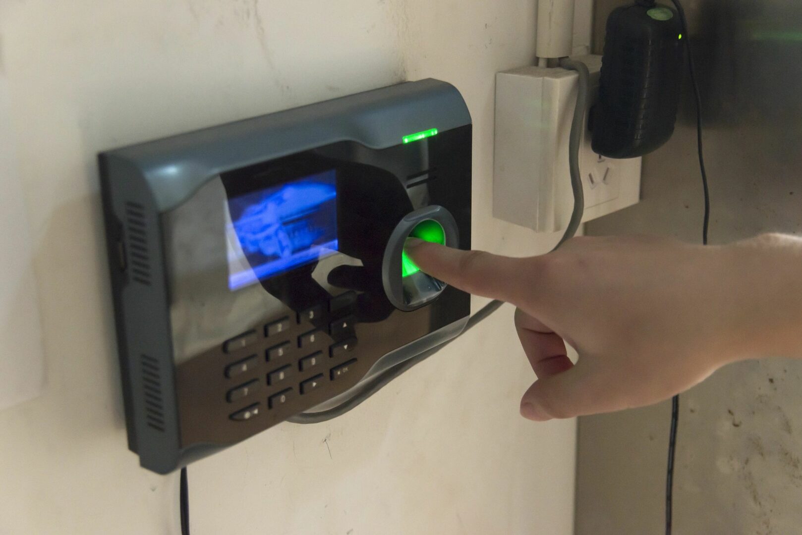 Person using a fingerprint scanner on a biometric device.
