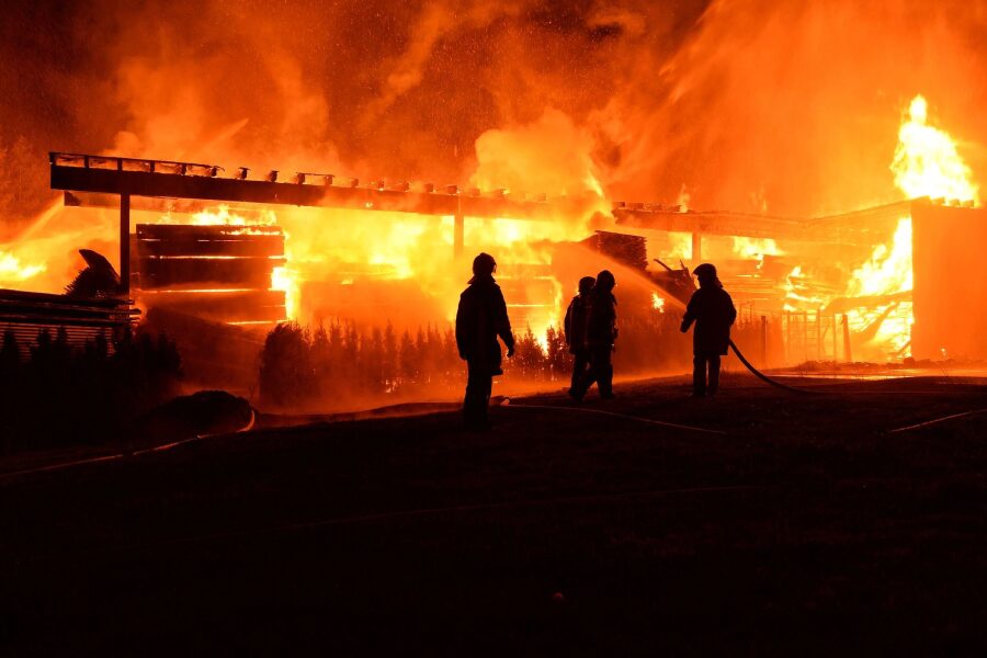 Firefighters battling a large blaze at night.